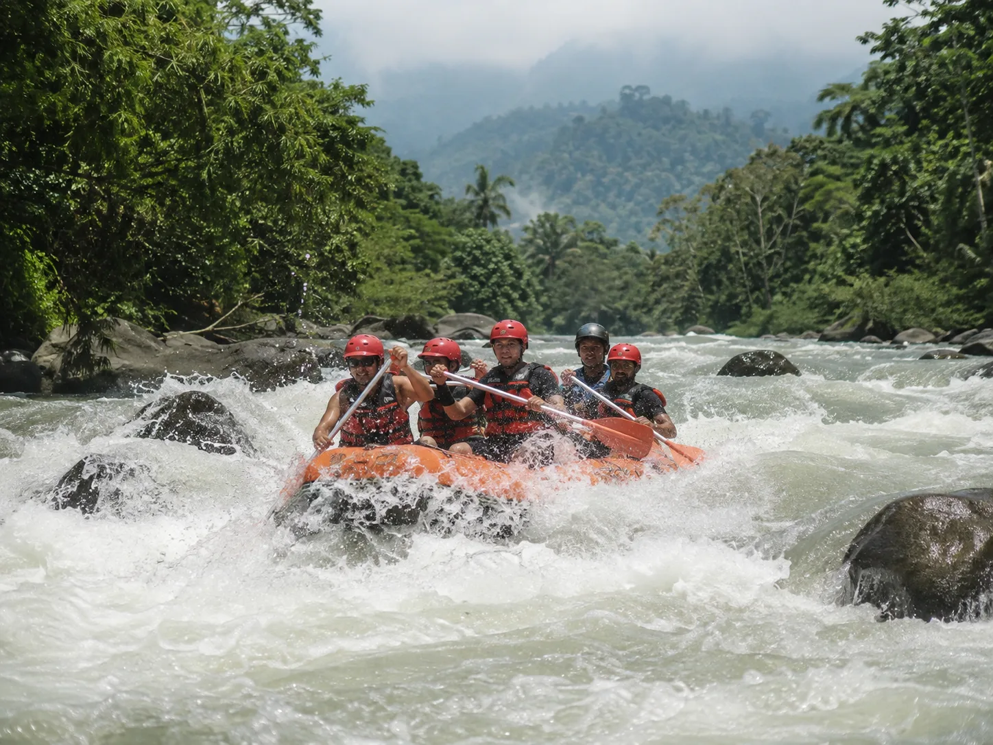 Rafting whitewater di sungai tropis pegunungan sebagai visual utama Caldera River Adventure